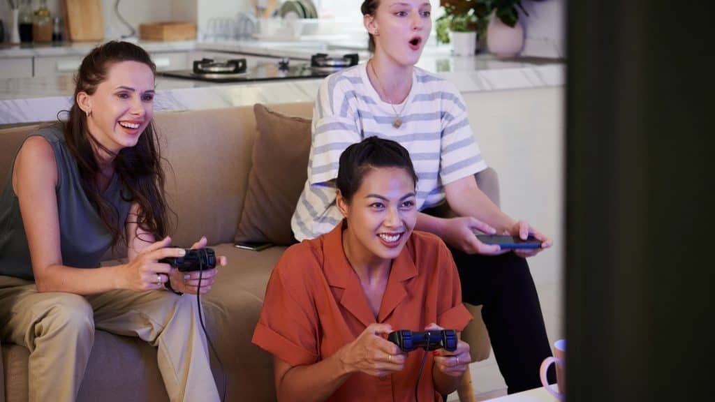Group of friends playing video games in the living room at home