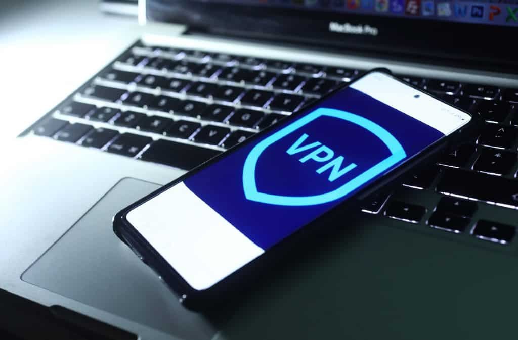 Image of a VPN logo in a smartphone, which is on a laptop